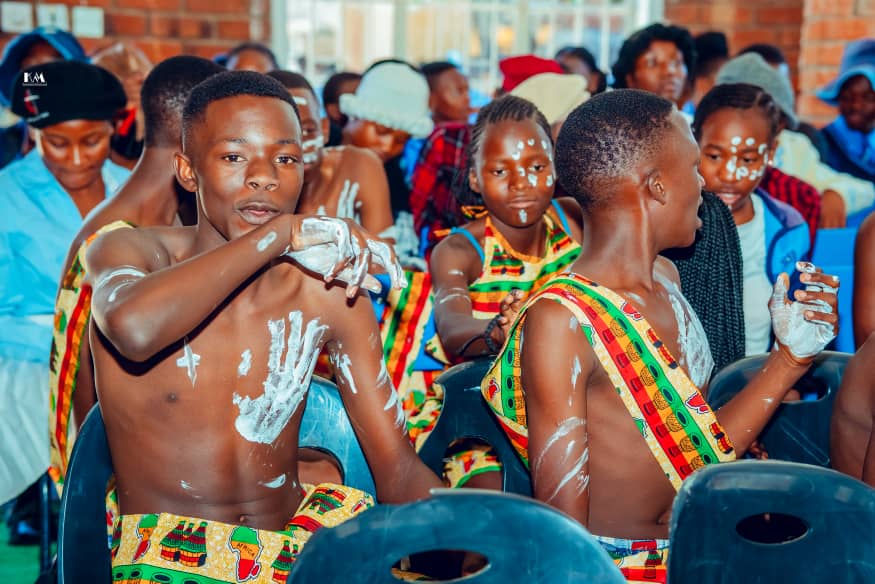 MFM Academy — Cultural performers seated together