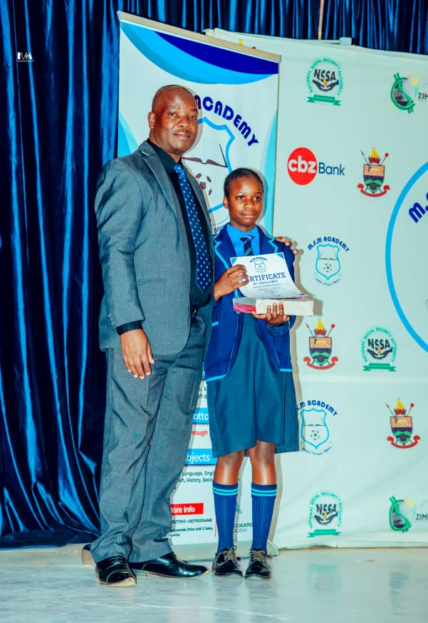 MFM Academy — Learner holding a certificate beside a presenter